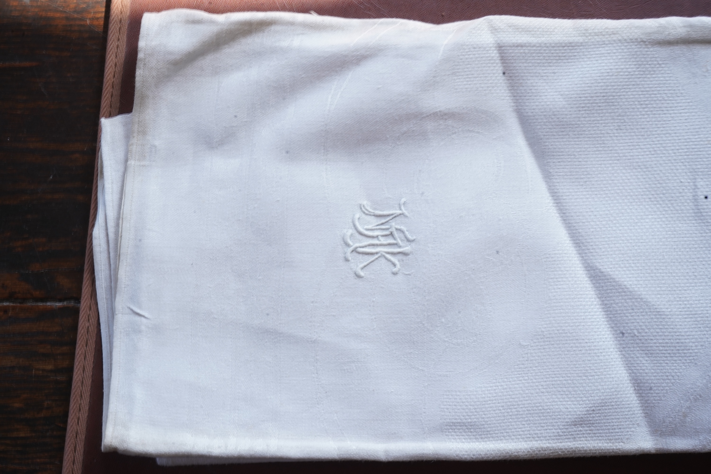 A set of four large Art Nouveau, unused white damask woven hand towels. The pattern having strong Archibald Knox and Walter Crane design elements; with trailing Honesty seeds and Tulip flower heads, these motifs much use
